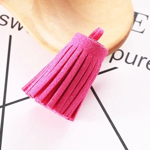 Close-up of rose red faux suede tassel with hanging loop on a decorative spoon