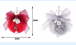 Detail view of 80mm faux fur ball keychain with bow, crystal beads and pearl charms