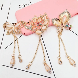 Detailed view of vintage gold-plated alloy brooches with cat-eye stones and long tassels