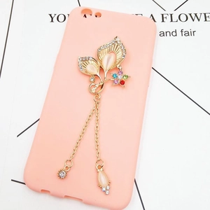 Detail of pink floral phone case charm with crystal butterfly and gold tassel chains