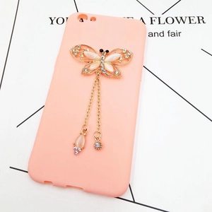 Close-up of pink phone case with golden butterfly pendant and metallic tassel chains