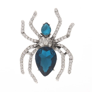Detail view of spider brooch with sparkling rhinestones and blue teardrop gems