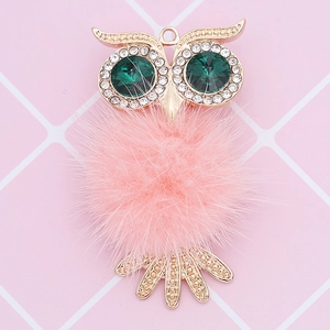 Detail of owl pendant with pink faux fur and green crystal eyes on a pink grid background