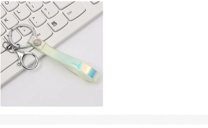 Detail view of iridescent laser PU leather keychain with silver lobster clasp on a surface
