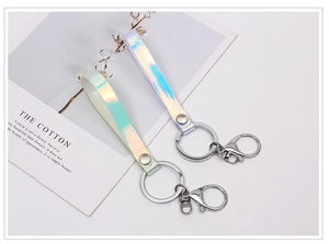 Close-up of holographic leather keychains with silver lobster clasps on a white background