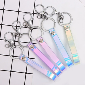 Iridescent laser PVC keychain set with silver lobster clasp on a grid background