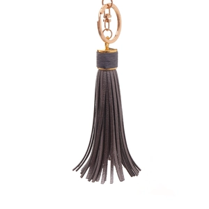 Close-up of leather tassel keychain with rose gold metal ring and spring clasp detail
