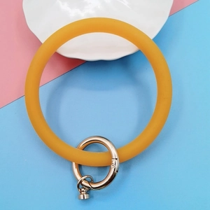 Close-up of ginger yellow silicone wristlet strap with gold-plated metal spring clasp