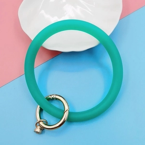 Close-up of mint green silicone bracelet keychain with a gold metal spring ring clasp
