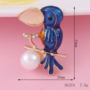 Detailweergave van de emaille vogelbroche, blauwe vleugels, parels en maten 34x28mm