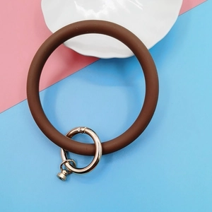 Macro view of a brown matte silicone wristlet ring with a golden spring metal clasp