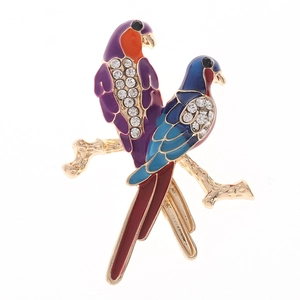 Detailopname van kleurrijke emaille vogels met strass op een gouden takje