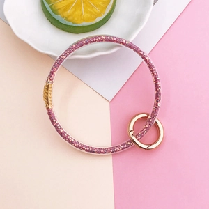 Detail of pink glitter filled transparent silicone bangle keychain with gold ring clasp