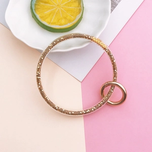Detail of transparent ring keychain filled with gold glitter and rose gold spring clasp