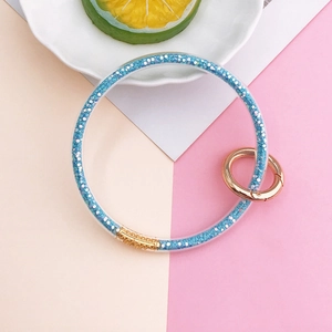 Blue glitter-filled clear silicone ring keychain with golden metal spring clasp and holder