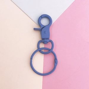 Detail of blue matte lobster clasp and spring ring keychain accessory on geometric background
