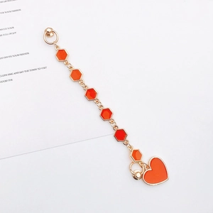 Detail of orange heart charm and hexagonal gold metal links for DIY phone case chain