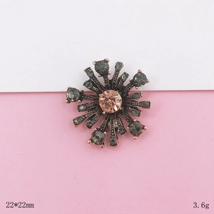Detail of 22x22mm vintage starburst charm with champagne gem and grey rhinestones