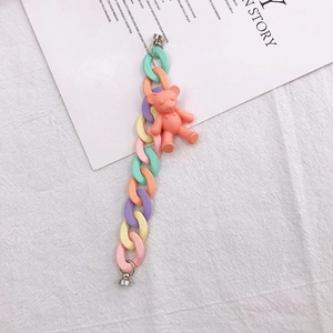 Macro detail of macaron acrylic chain strap with a cute pink bear pendant for phone cases