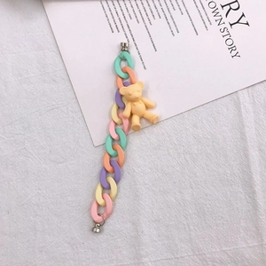 Detail of macaron acrylic chain strap with a matte yellow bear pendant for phone case