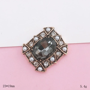 Macro detail of 23x19mm vintage gold floral charm with grey crystal and pearls