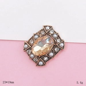 Macro detail of retro champagne crystal oval charm with pearls and rhinestones 23x19mm