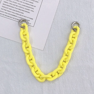 Detail of yellow acrylic chain strap with silver metal spring rings on white background