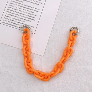 Macro shot of bright orange acrylic chain strap with silver metal spring rings