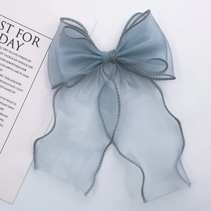 Dettaglio di un fiocco in organza azzurro con bordi rifiniti per accessori per capelli