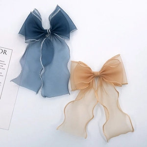 Large organza mermaid lace bow hair clip in champagne and navy blue with wavy edges