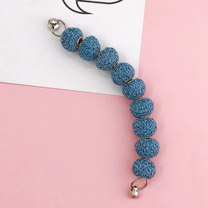 Detail of blue woven ball phone case chain with gold metal rings and separators