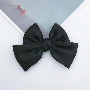Elegant large black satin ribbon bow hair clip with a smooth silky texture on white background