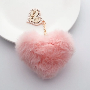 Detailed macro view of a pink faux fur heart pendant with I Love You engraving and rhinestones