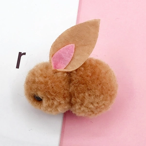 Close-up of cute brown plush bunny head with soft pom-pom texture and felt ears for DIY