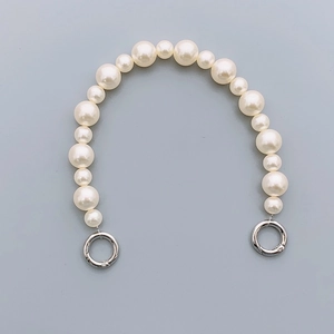 Detailed view of white pearl handbag strap with silver spring buckles for DIY phone cases