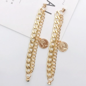 Bracelet double chaîne doré avec breloque pièce Reine Elizabeth II sur fond blanc