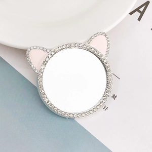 Dettaglio dello specchio da trucco rotondo con strass scintillanti e orecchie di gatto rosa