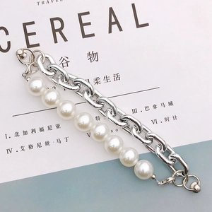 Dubbellaagse armband met zilveren metalen ketting en witte parels op een Cereal-tijdschrift