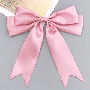 Détail d'un nœud en satin rose pour cheveux avec longs rubans et texture soyeuse