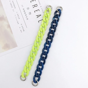 Dettaglio di catene in acrilico lucido in verde neon e blu marmo con anelli argento