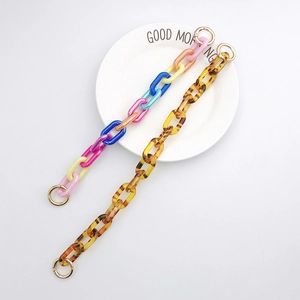 Detail of colorful resin and amber acrylic chain straps with golden metal ring hooks