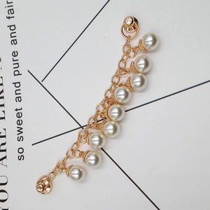 Detailed view of DIY pearl chain with gold floral caps and polished metal links
