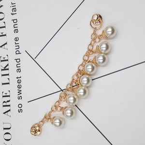 Detailed macro view of golden chain jewelry with white pearls for DIY creative accessories