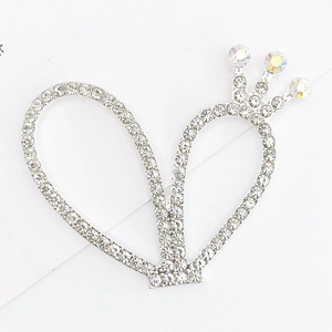 Detalle de accesorio de corona de corazón plateado con pedrería brillante y cristales AB