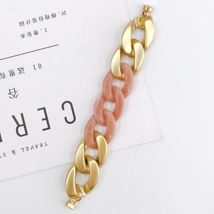 Detail of pink resin and gold metal link chain bracelet on a minimalist lifestyle background