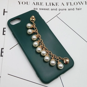 Detail of dark green phone case with golden metal chain and large white pearls