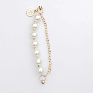 Detailed view of the double pearl chain strap with a golden camellia flower pendant