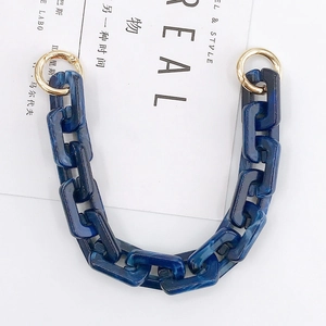 Macro view of blue marble acrylic chain strap with golden metal spring ring clasps