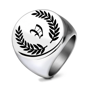 Macro detail of vintage stainless steel signet ring with gothic letter W and laurel leaves