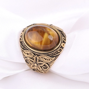 Vue détaillée d'une bague vintage en acier avec pierre œil de tigre et gravures florales